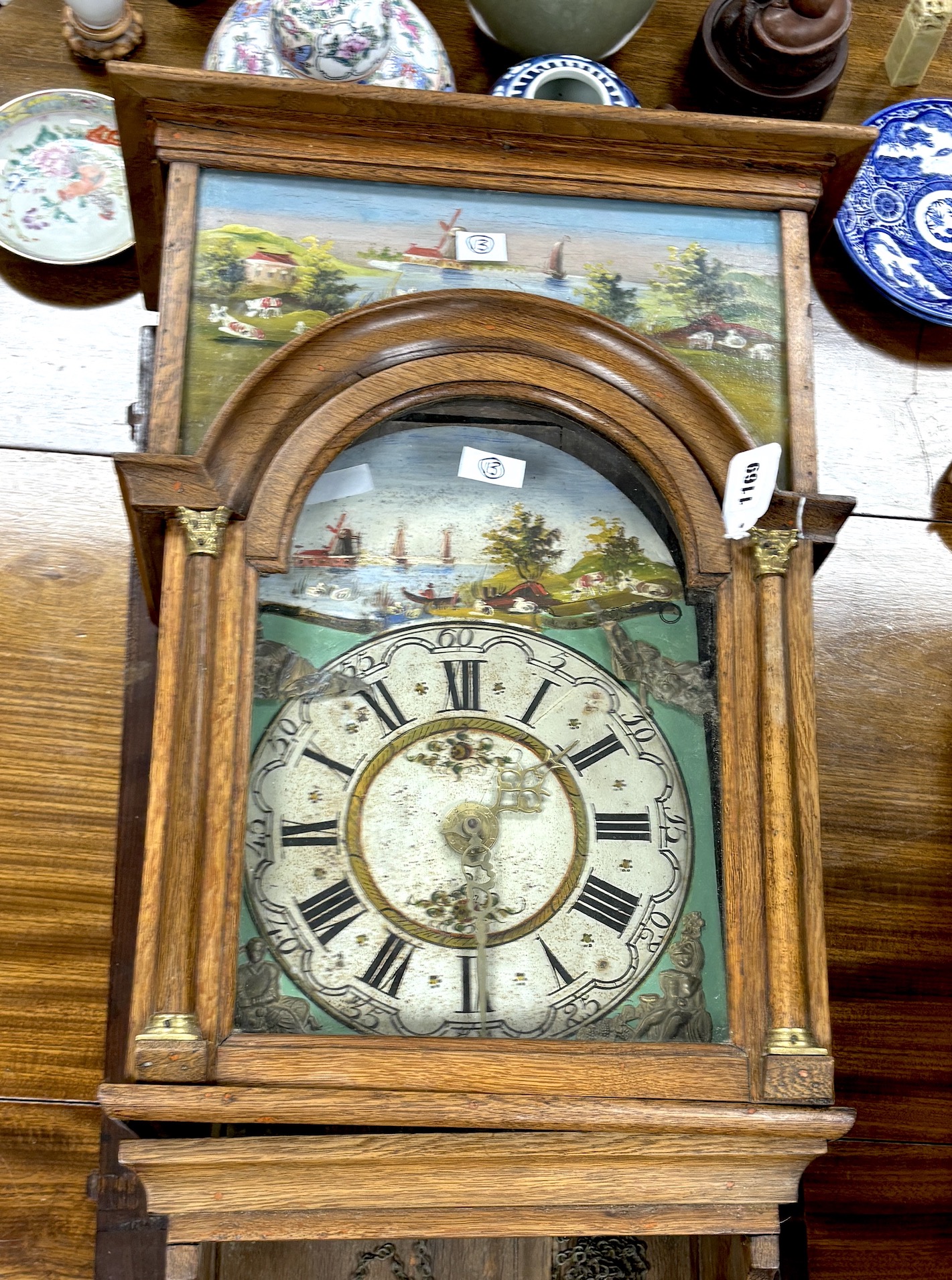 An oak cased Dutch wall clock with arched painted dial, case inset painted landscape panels, height 140cm